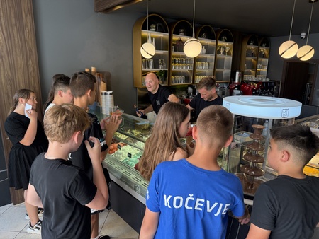 Podžupan in župan v slaščičarni delita kepice sladoleda otrokom